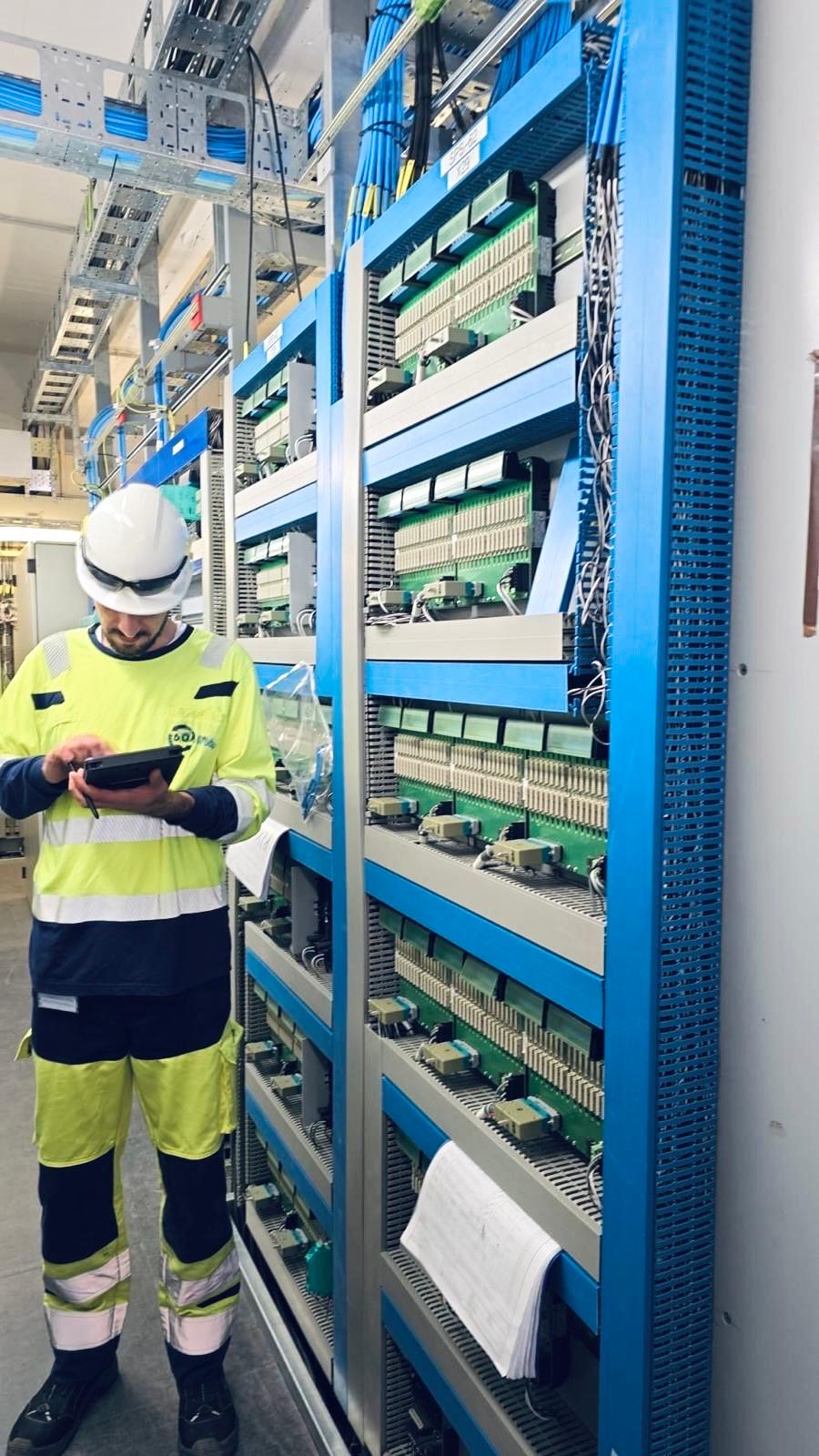 Techniker mit Tablet vor Schaltkasten